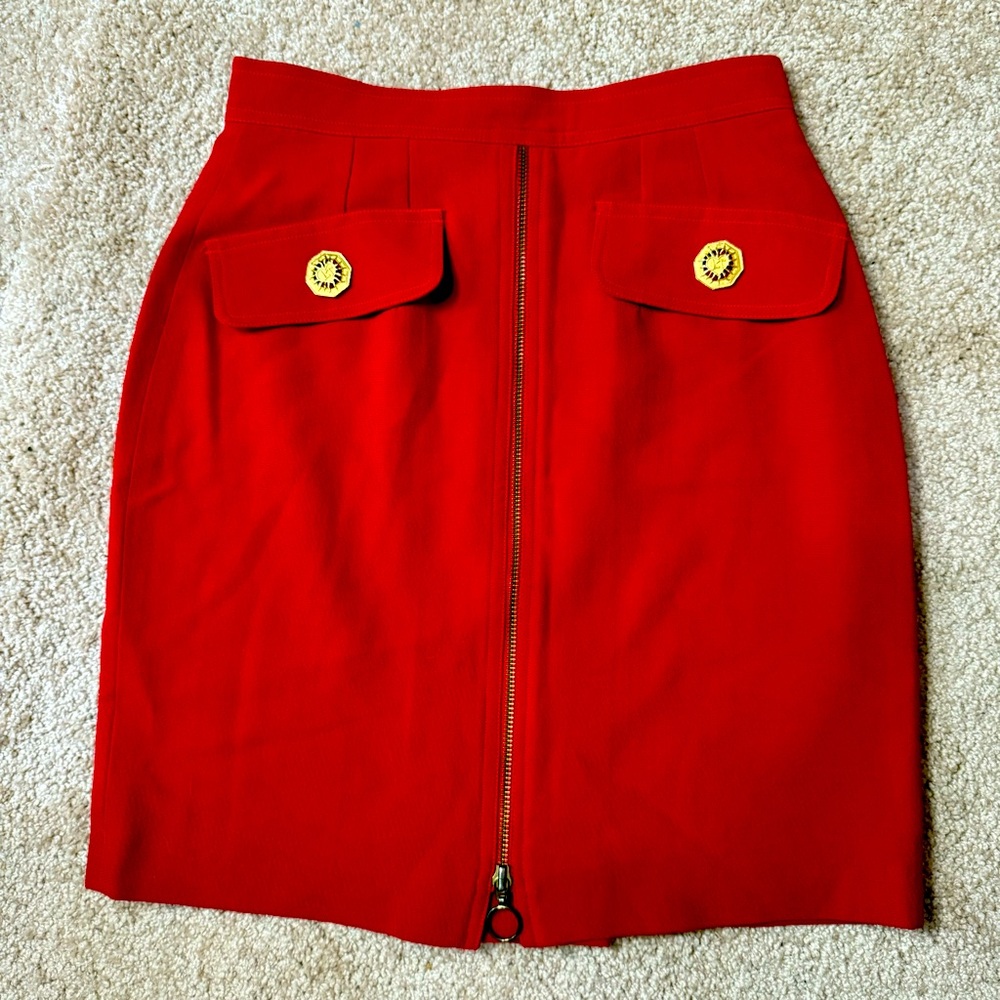 Red Mopete skirt with a kind of scared heart buttons on the pockets.
